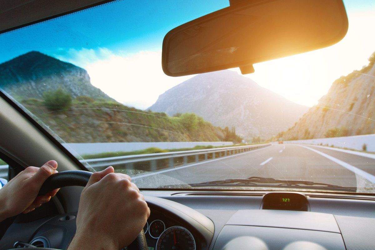Vue depuis le volant sur une route de montagne au lever du soleil